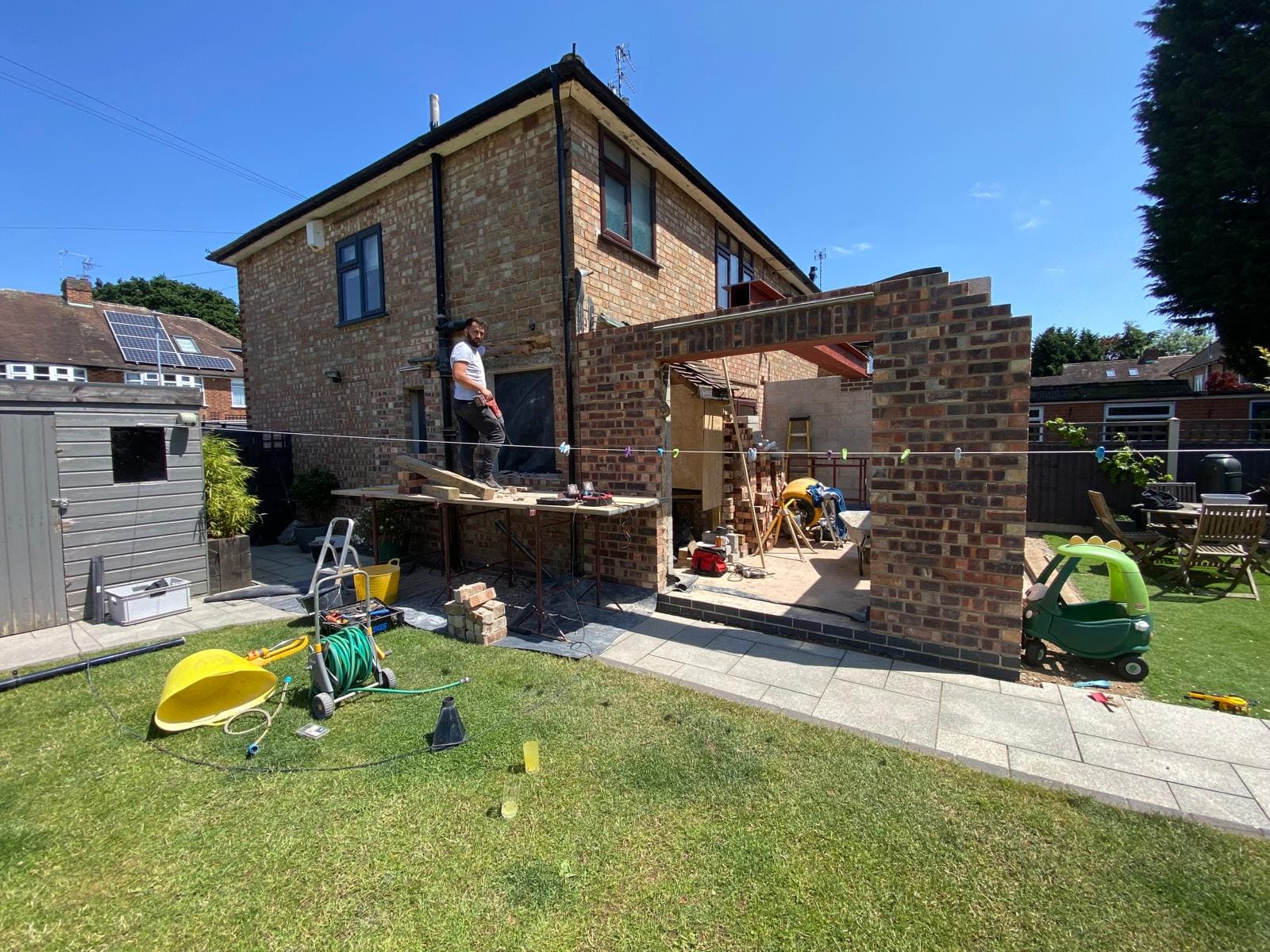 Reclaimed brick extension walls and steelwork against a clear sky