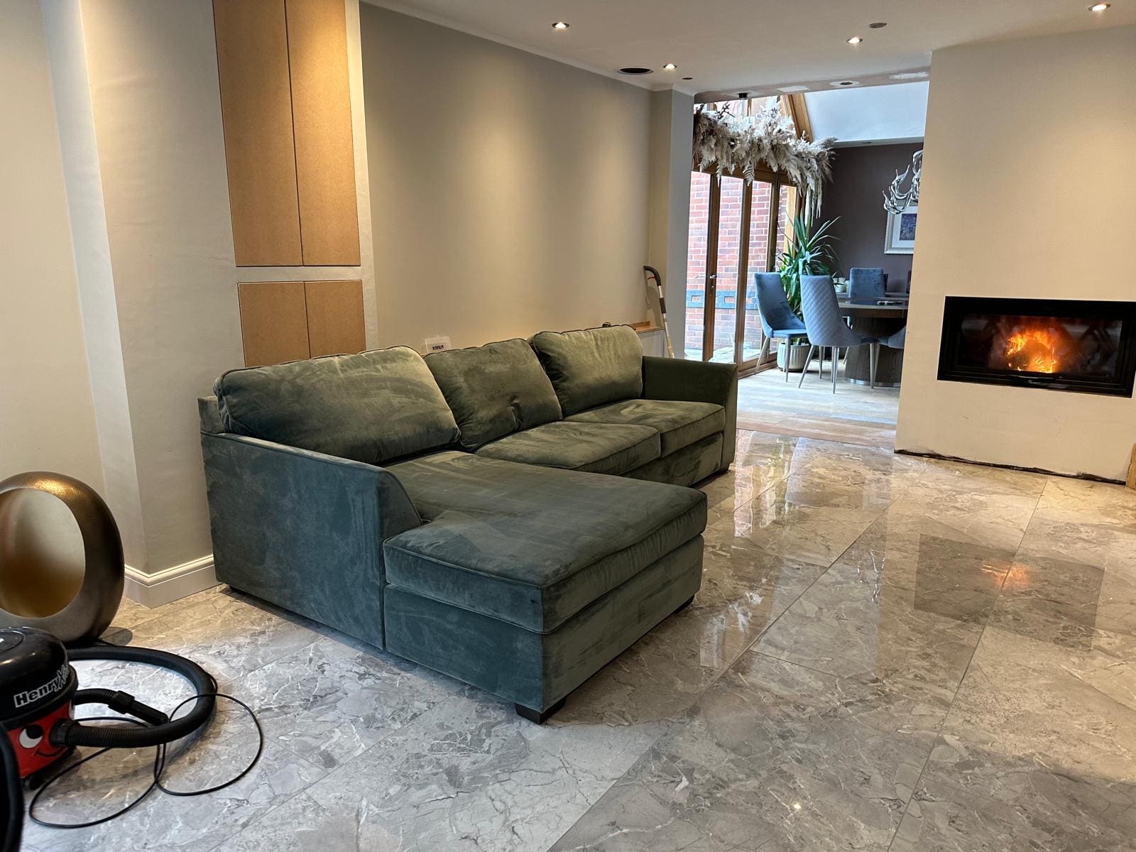 A finished open-plan living room with the wood burner lit